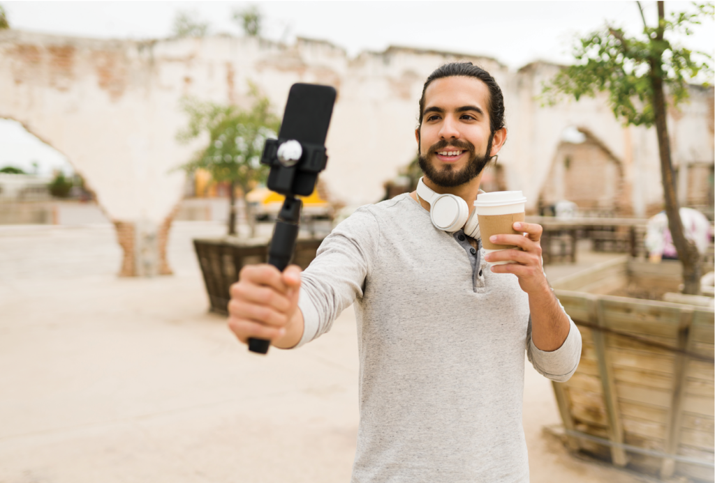 Happy social media influencer filming himself with a smartphone